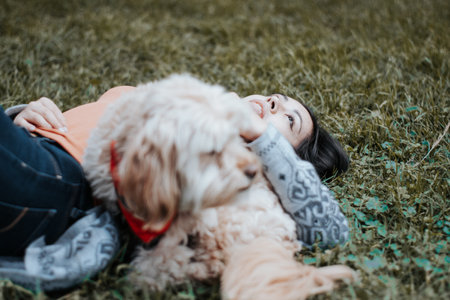 <p>Girl lying in the park together with her dog. Girl lying in the park looking at the sky.</p>の写真素材