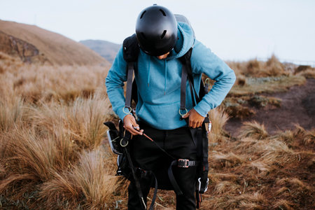 Man makes sure to jump on the paraglider. A man secures his equipment to fly