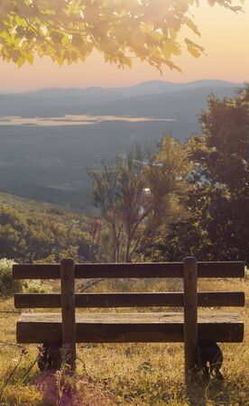 bench in the mountain with views towards the horizon at sunsetの写真素材