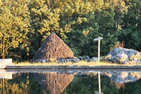 thatched cottage next to mountain water pond for shepherdsの写真素材
