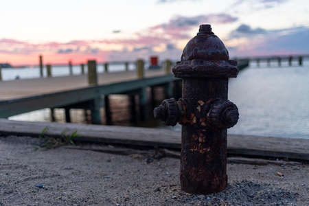 silhouette of fire hydrant at dusk next to jetty pierの写真素材
