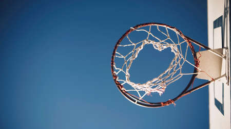 Basketball basket with net in plane from below with blue sky