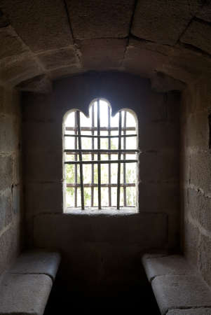 Granadilla castle interior, window with iron fence and old wooden door 2
