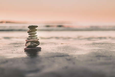 stones balanced on the shore of the beach to meditate and seek balanceの写真素材