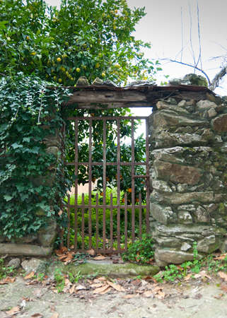 Wrought iron gate in slate wall with wooden roof in Robledillo de Gataの写真素材