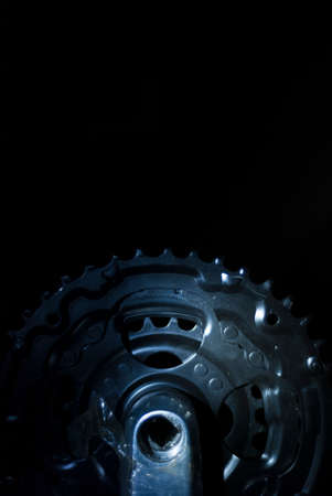 Backlit black mountain bike chainrings with black backgroundの写真素材