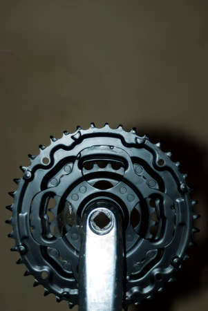 black metallic mountain bike chainring with dark background in vertical with area for copy pasteの写真素材