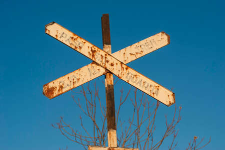 Train level crossing sign with blue sky in horizontalの写真素材