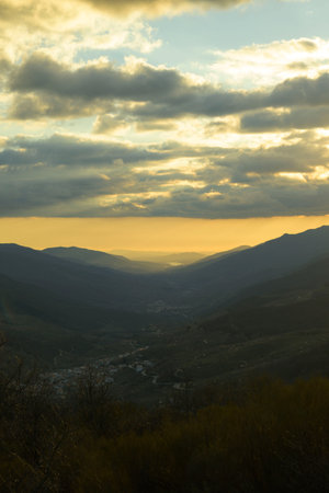 Valle del Jerte from the port of Tornavacas at sunset in winter with sky with clouds in verticalの写真素材