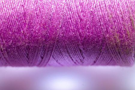 Spool of purple thread for sewing with white background horizontally with copy spaceの写真素材