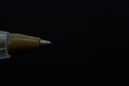 Detail of blue ink pen tip horizontally with black background and copy paste