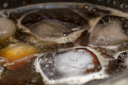 Ice cold black coffee with foam and bubbles macro photography in flatの写真素材