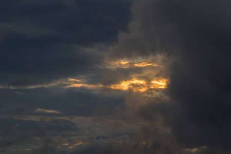 Sky with gray clouds and sun light at sunsetの写真素材