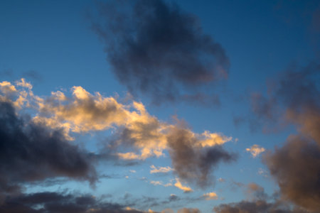 Sunlit white and gray clouds with blue sky horizontallyの写真素材