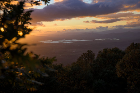 Sunset in a mountain area with water in the background with autumn lightの写真素材