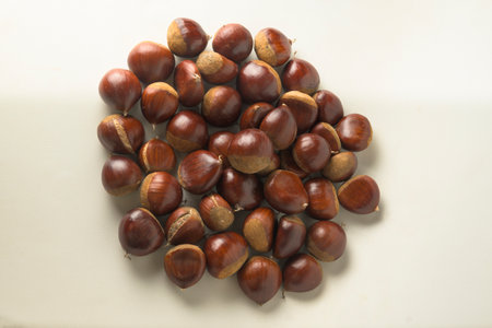 Raw chestnuts ready to eat or roast with white background horizontal Castanea sativaの写真素材