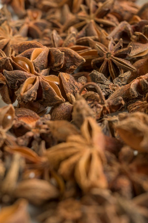 Detailed close up of dried star anise pods showing natural texture and warm brown tones, perfect for culinary or aromatic spice themes.の写真素材