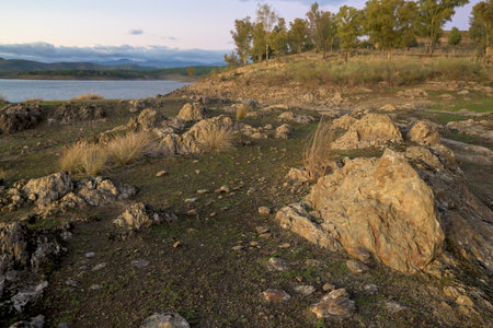 Vertical close up of dark gray slate rock formations found along the shore of the reservoir. The layered texture and sharp edges of the metamorphic rock are highlighted.の写真素材