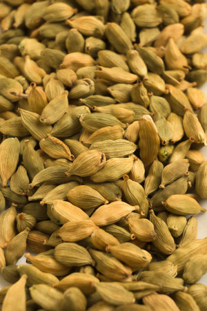 Heap of dried green cardamom pods showing natural texture and warm tones ideal for culinary spice and food related conceptsの写真素材