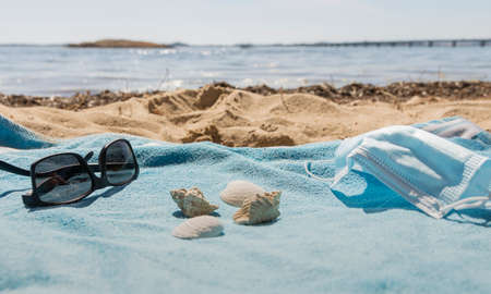 view of the beach from the towel with the mask on a sunny day. Accompanied by some shells.の写真素材