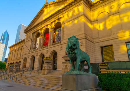Close-up lion at the Chicago Museum of Art. With beautiful colors generated by the sunset with reflections of the sun and in the background large buildings and a totally clear skyのeditorial素材