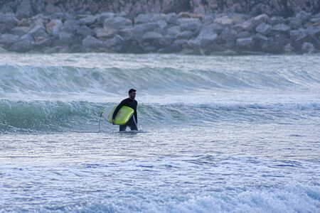 Young surfer in a summer surf session during sunset in northern Spain on a sunny dayの写真素材