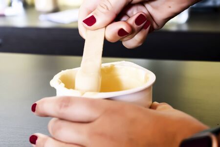 Girl takes depilatory wax to shaveの写真素材