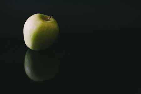Single apple reflected on black backgroundの写真素材