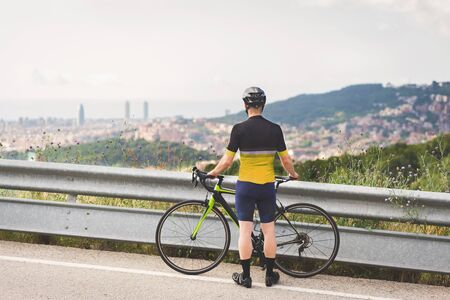 Professional cyclist looking at the cityの写真素材
