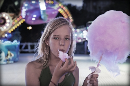 Teenager in fairground eating a sweetの写真素材