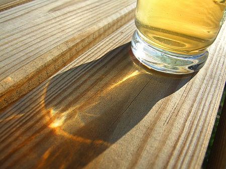 One glasses of cold beer backlit on the wooden table の写真素材