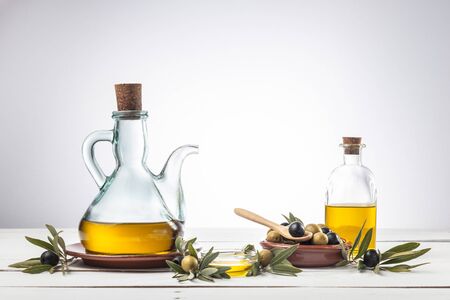 Olive oil and olive branch on wooden table, White backgroundの写真素材