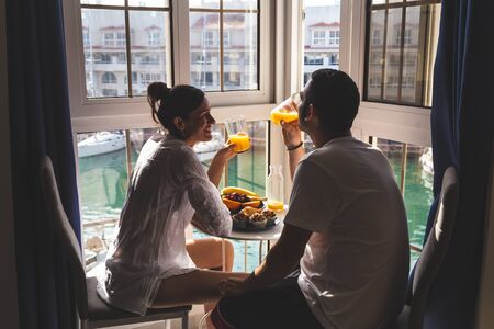 Happy young Couple Enjoying Breakfast on the terrace at the marina. Relationship and lifestyle concept.の写真素材