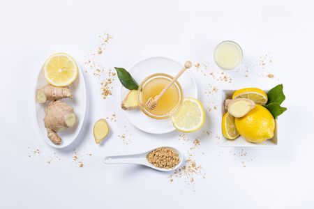 Ginger, honey and lemon, in white plates and spoon on white background. Top view. Natutal food and brevage concept.の写真素材