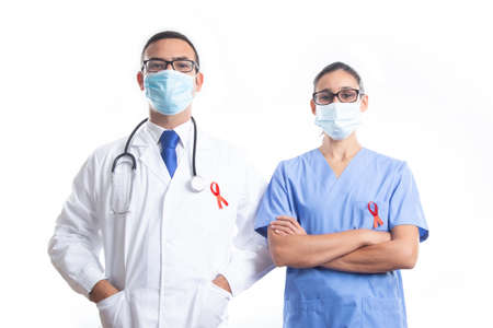 Doctor and nurse wearing mark, with red AIDS ribbon on white background. World AIDS Day concept.の写真素材