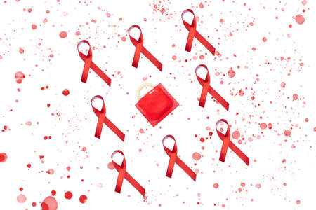 Red AIDS ribbon and condom with red splashes on white background. World AIDS Day concept.