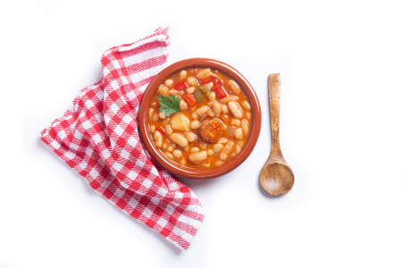 Traditional Spanish dish of beans stew with chorizo and potatoes, on white background.Top view.の写真素材