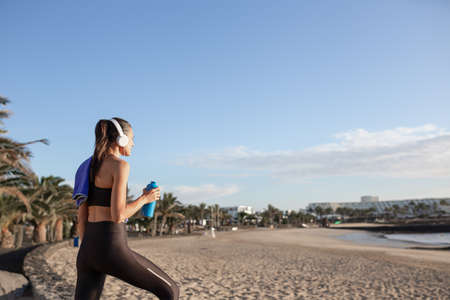 Beautiful fitness woman looking at the beach after training.の写真素材