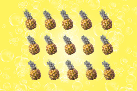 Symmetrical composition of pineapple on yellow background. Top view.の写真素材