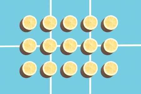 Symmetrical composition of lemon slices on blue background. Top view.の写真素材