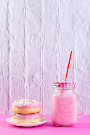 strawberry shake and donuts on white and pastel pink background.の写真素材
