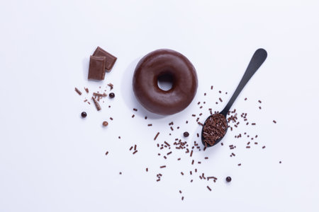 Chocolate donuts and chocolate chips on white background. Top view.の写真素材