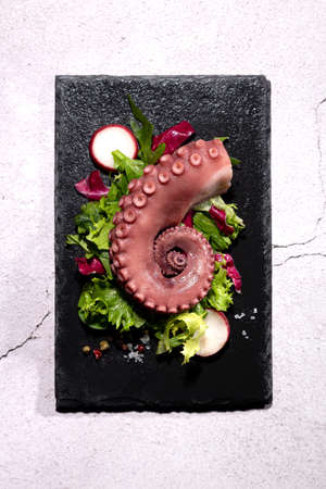 stew octopus tentacles on a stone plate. Top view. Vertical format.の写真素材
