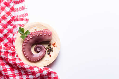 stew octopus tentacles on wooden plate on white background with copy space, Top view.の写真素材