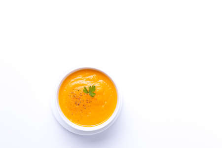 Bowl of carrot soup isolated on white background with copyspace. Top view.の写真素材