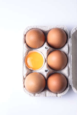 Top view of brown eggs on egg carton isolated on white background.