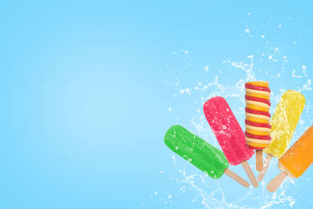Colorful popsicles ice cream splash on blue background with copy space.