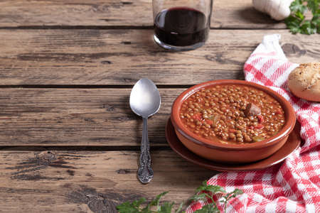 Traditional Spanish dish of lentil stew with chorizo on wooden background with copy space. Healthy food concept.の写真素材