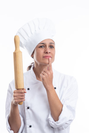 Portrait of young Caucasian chef thinking what dish she will make now on white background. Portrait format.の写真素材