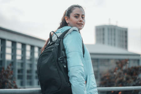 Smiling teenage medical student with backpack waiting for exam on school grounds